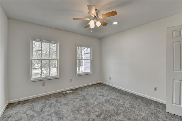 empty room featuring ceiling fan and light carpet