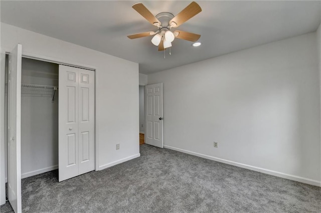 unfurnished bedroom featuring ceiling fan, dark carpet, and a closet