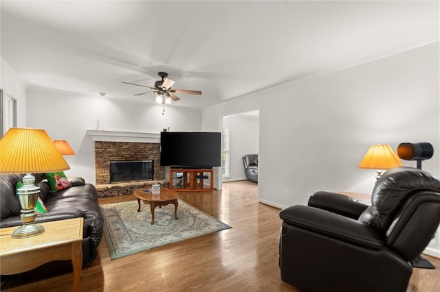 1418 Mill Path Loop, Lawrenceville, GA 30045 - living area featuring crown molding, ceiling fan, wood finished floors, and a stone fireplace