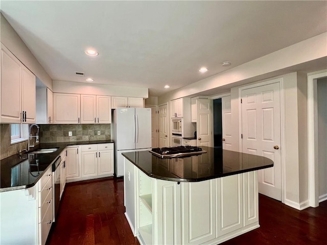 415 Wood Trace Ct, Alpharetta, GA 30022 - kitchen with stainless steel appliances, dark wood finished floors, decorative backsplash, white cabinetry, and a kitchen island