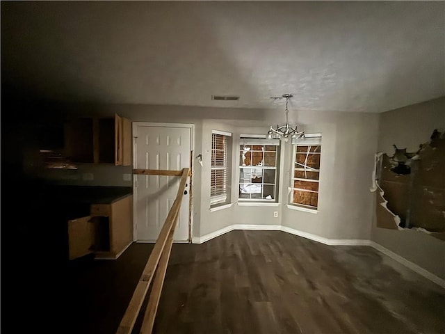 dining area with dark wood-style floors, visible vents, a chandelier, and baseboards