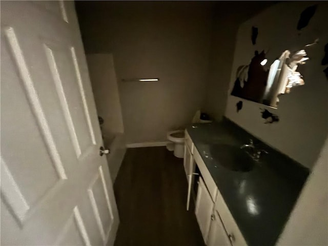 bathroom featuring baseboards, toilet, and vanity