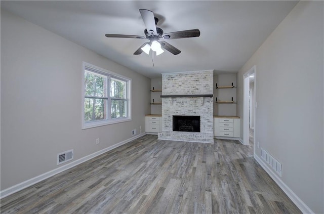 380 Inman Rd, Fayetteville, GA 30215 - unfurnished living room with wood finished floors, a ceiling fan, a brick fireplace, and baseboards
