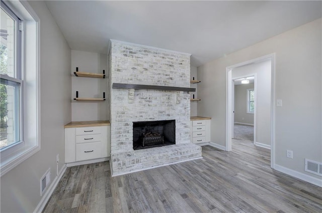 380 Inman Rd, Fayetteville, GA 30215 - unfurnished living room featuring light wood-type flooring, baseboards, and a brick fireplace