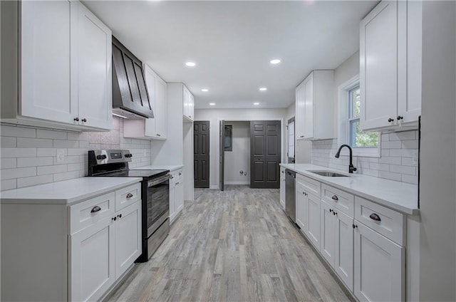 380 Inman Rd, Fayetteville, GA 30215 - kitchen with appliances with stainless steel finishes, a sink, wall chimney range hood, light countertops, and backsplash