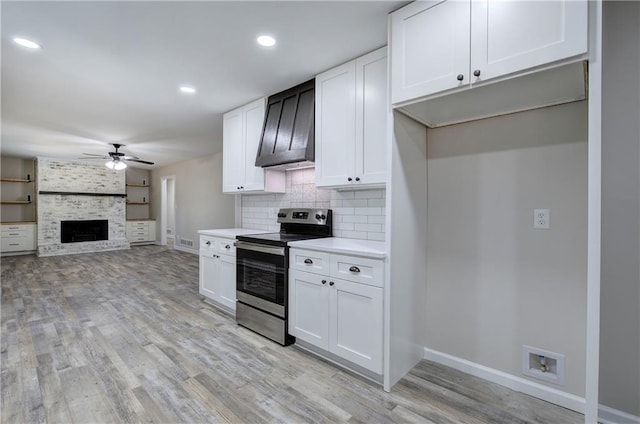 380 Inman Rd, Fayetteville, GA 30215 - kitchen featuring stainless steel range with electric stovetop, a ceiling fan, light wood-type flooring, baseboards, and white cabinets