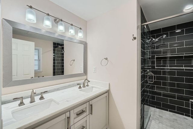 bathroom with double vanity, tiled shower, and a sink