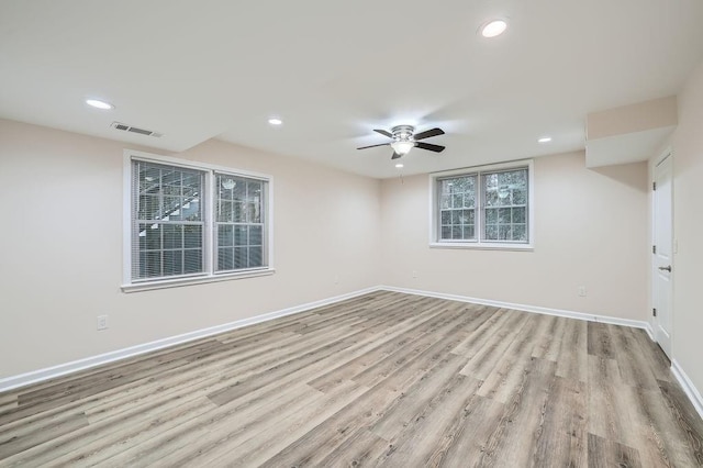 empty room with baseboards, visible vents, wood finished floors, and recessed lighting