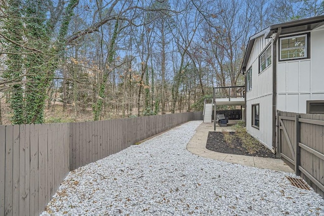 view of yard featuring a fenced backyard, stairway, and a wooden deck