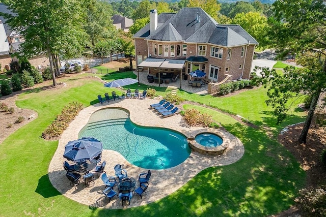 rear view of property featuring a yard, a pool with hot tub, and a patio area