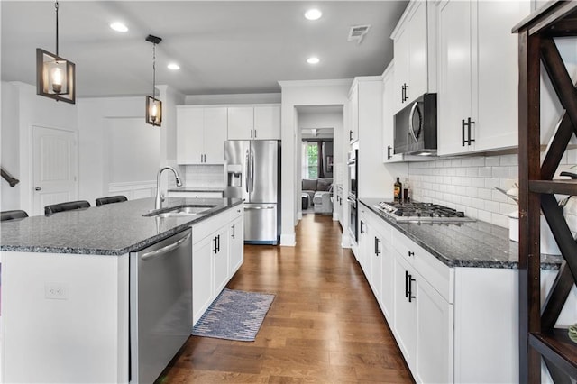 216 Orchard Trl, Canton, GA 30115 - kitchen with stainless steel appliances, a sink, a center island with sink, backsplash, and white cabinets