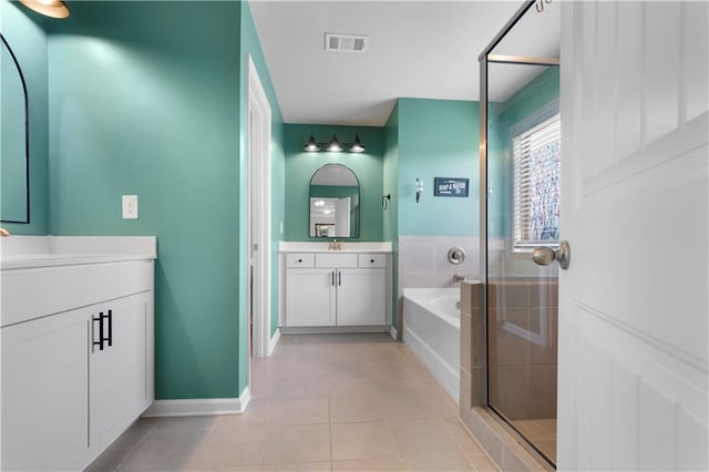 216 Orchard Trl, Canton, GA 30115 - full bathroom featuring tile patterned flooring, a garden tub, two vanities, a stall shower, and baseboards