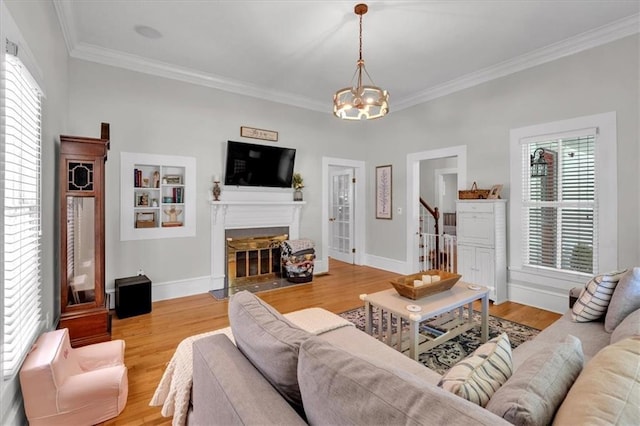 1238 Macland Rd, Dallas, GA 30132 - living area featuring a chandelier, ornamental molding, healthy amount of natural light, a fireplace with flush hearth, and light wood-type flooring