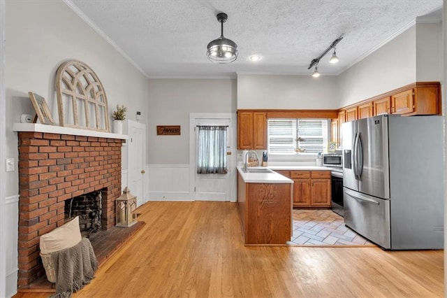 1238 Macland Rd, Dallas, GA 30132 - kitchen with stainless steel appliances, brown cabinets, light countertops, decorative light fixtures, and crown molding