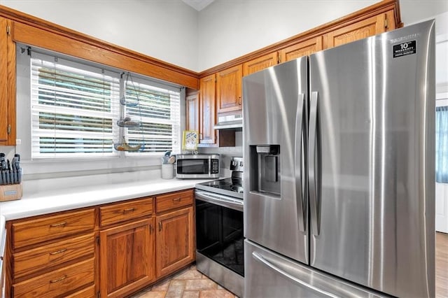 1238 Macland Rd, Dallas, GA 30132 - kitchen featuring stainless steel appliances, exhaust hood, brown cabinetry, and light countertops