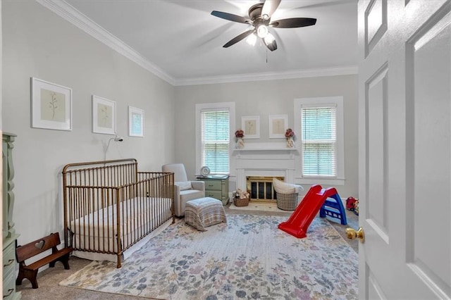 1238 Macland Rd, Dallas, GA 30132 - carpeted bedroom with multiple windows, ornamental molding, a crib, a ceiling fan, and a glass covered fireplace