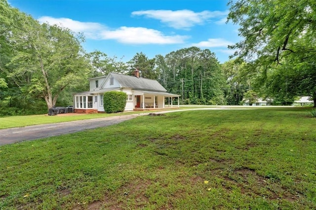 1238 Macland Rd, Dallas, GA 30132 - view of front of home featuring a chimney, a front yard, a porch, asphalt driveway, and view of wooded area