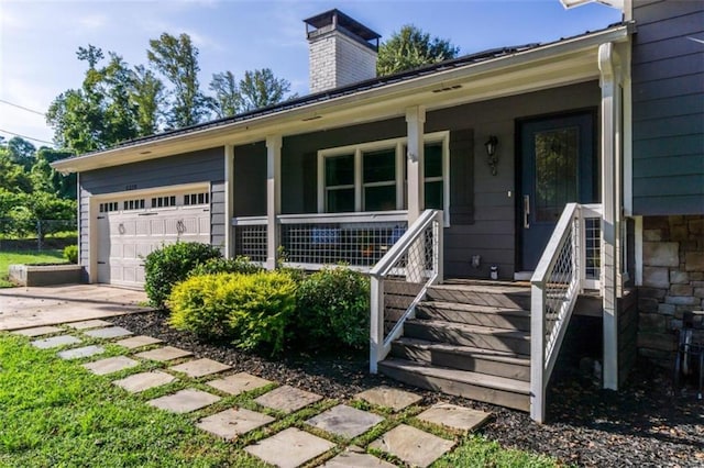 view of exterior entry with a garage and covered porch