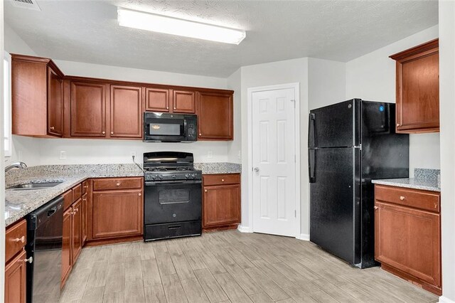 2146 Silva Ct, Conley, GA 30288 - kitchen with black appliances, light wood-style floors, a sink, light stone counters, and brown cabinets