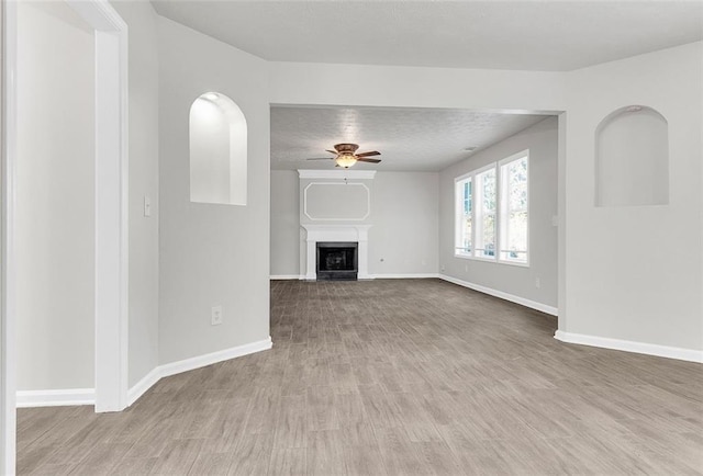 2146 Silva Ct, Conley, GA 30288 - unfurnished living room featuring a ceiling fan, baseboards, wood finished floors, and a textured ceiling