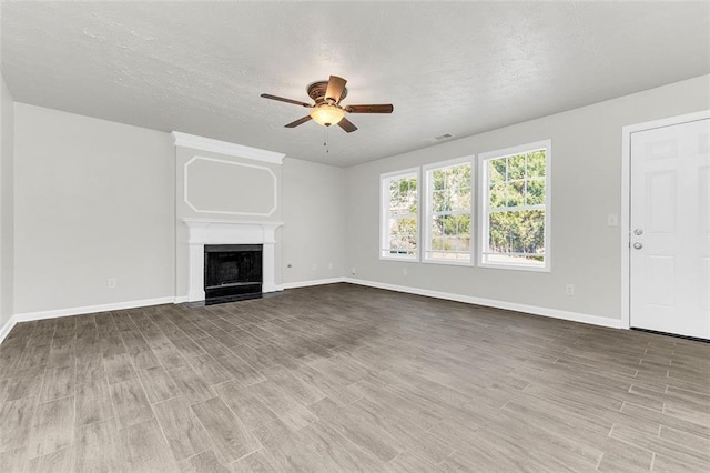 2146 Silva Ct, Conley, GA 30288 - unfurnished living room with ceiling fan, wood finished floors, baseboards, and a textured ceiling