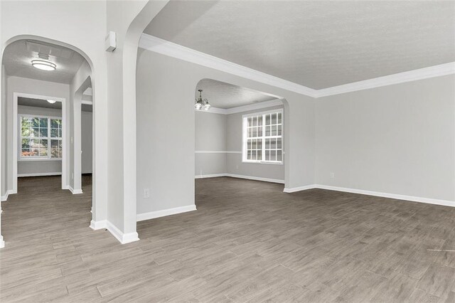 2146 Silva Ct, Conley, GA 30288 - empty room featuring baseboards, arched walkways, wood finished floors, and ornamental molding