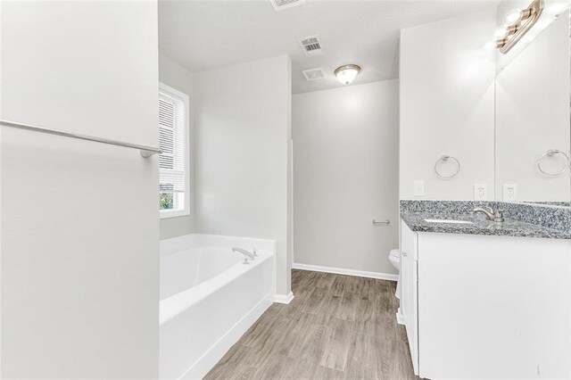 2146 Silva Ct, Conley, GA 30288 - full bathroom featuring vanity, toilet, wood finished floors, a bath, and baseboards