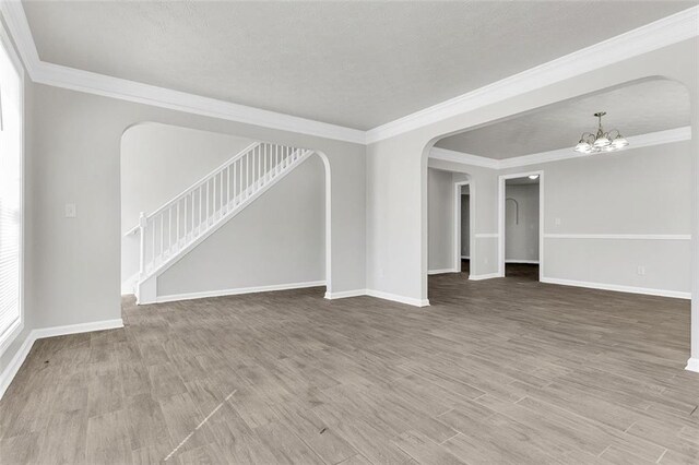 2146 Silva Ct, Conley, GA 30288 - unfurnished living room featuring arched walkways, a chandelier, baseboards, stairs, and ornamental molding