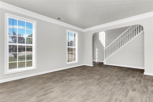 2146 Silva Ct, Conley, GA 30288 - spare room featuring arched walkways, wood finished floors, plenty of natural light, baseboards, and ornamental molding