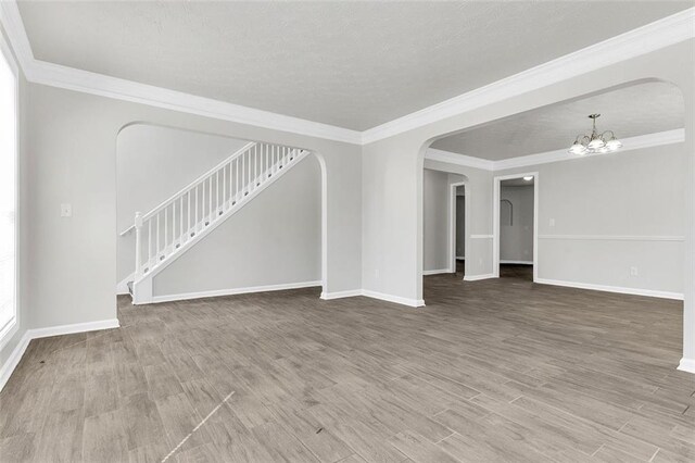 2146 Silva Ct, Conley, GA 30288 - unfurnished living room with a chandelier, baseboards, ornamental molding, and wood finished floors