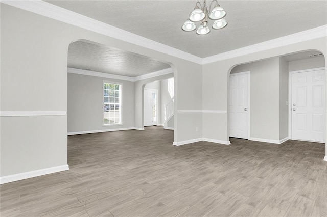2146 Silva Ct, Conley, GA 30288 - empty room with arched walkways, wood finished floors, baseboards, a chandelier, and crown molding