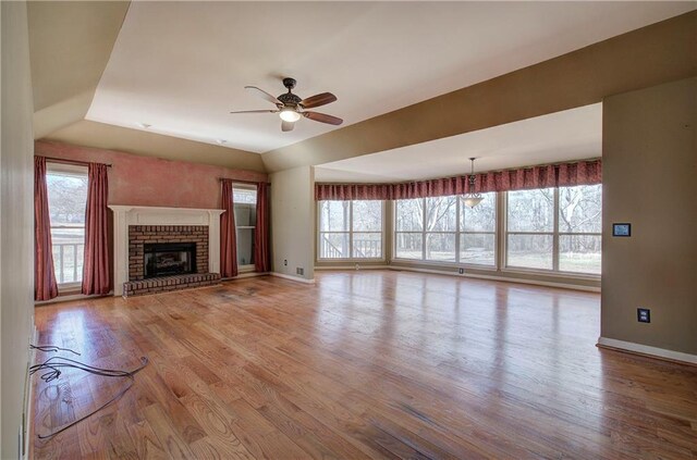 unfurnished living room featuring light wood-type flooring, ceiling fan, and a fireplace