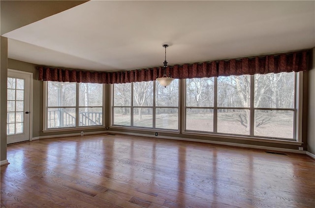 unfurnished dining area featuring hardwood / wood-style flooring and a wealth of natural light