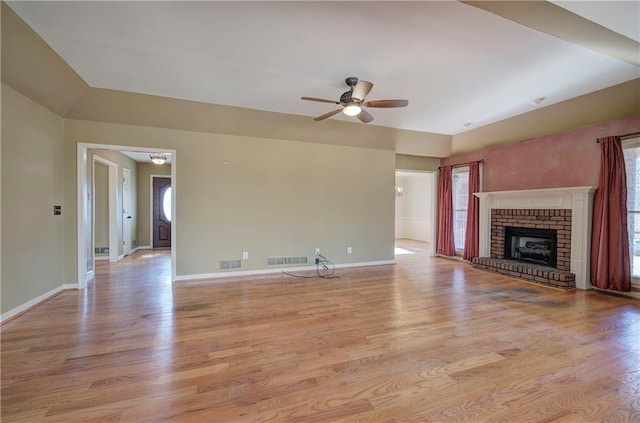 unfurnished living room with ceiling fan, light hardwood / wood-style floors, a healthy amount of sunlight, and a fireplace