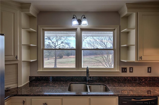 kitchen featuring black dishwasher, dark stone countertops, and sink