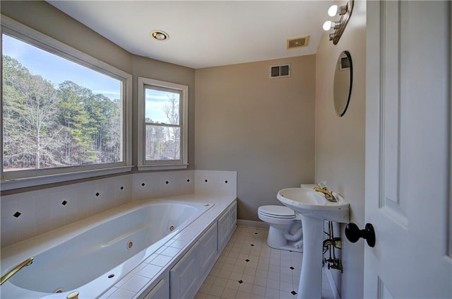 bathroom with a bathtub, tile patterned floors, and toilet