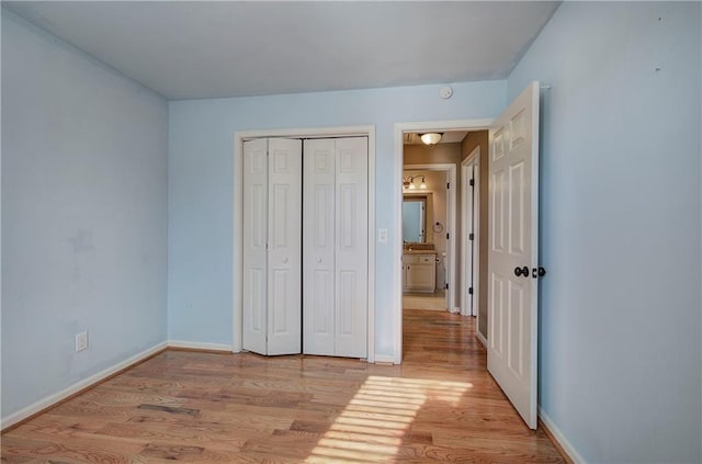 unfurnished bedroom featuring a closet and light hardwood / wood-style flooring