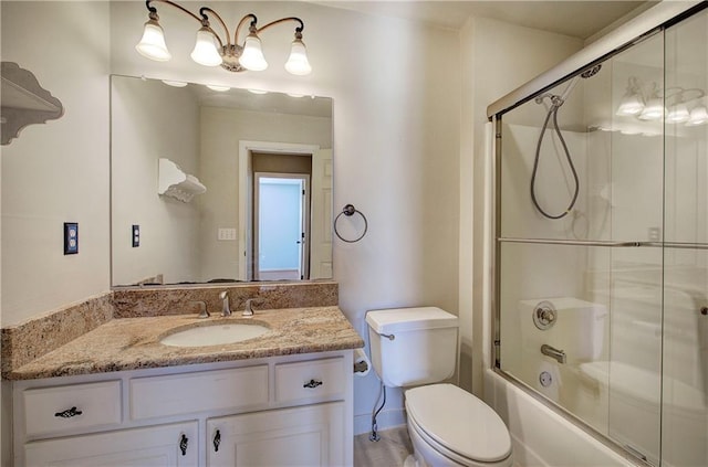 full bathroom featuring toilet, bath / shower combo with glass door, and vanity