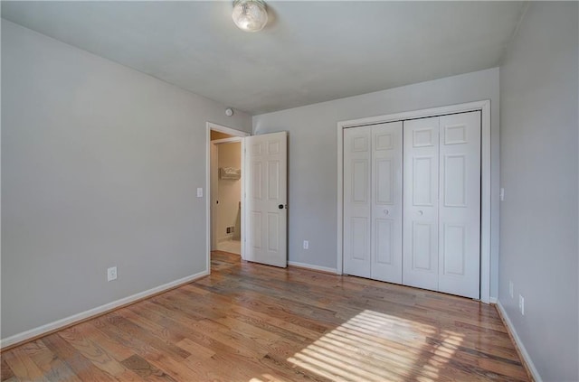 unfurnished bedroom featuring light wood-type flooring and a closet