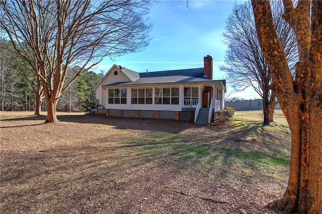 rear view of house featuring a lawn and a porch