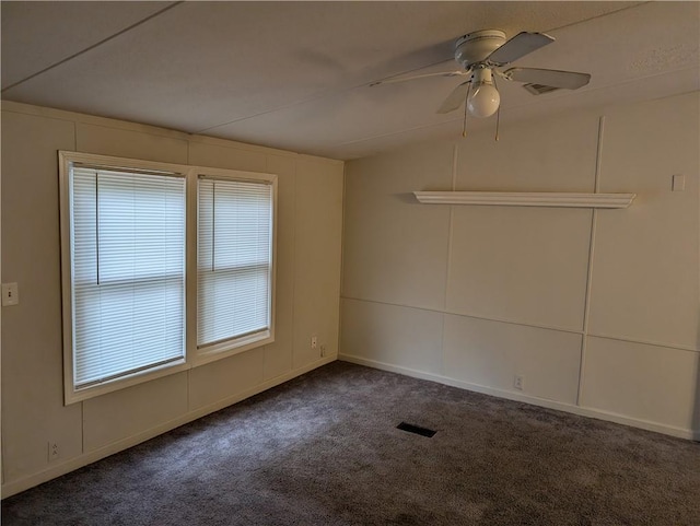 carpeted spare room with visible vents and a ceiling fan