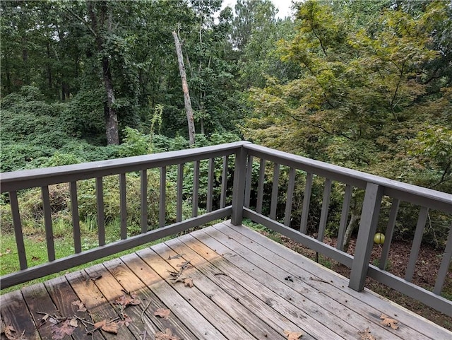 wooden terrace featuring a wooded view
