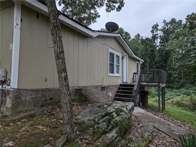 view of home's exterior with stairway, crawl space, and a deck
