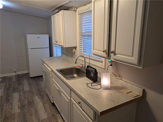 kitchen featuring white cabinets, dark wood-style flooring, a sink, white appliances, and light countertops