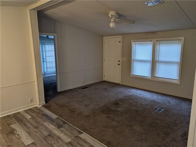 empty room with a healthy amount of sunlight, a ceiling fan, wood finished floors, and visible vents