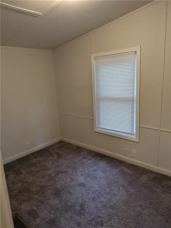 unfurnished room with dark colored carpet and baseboards