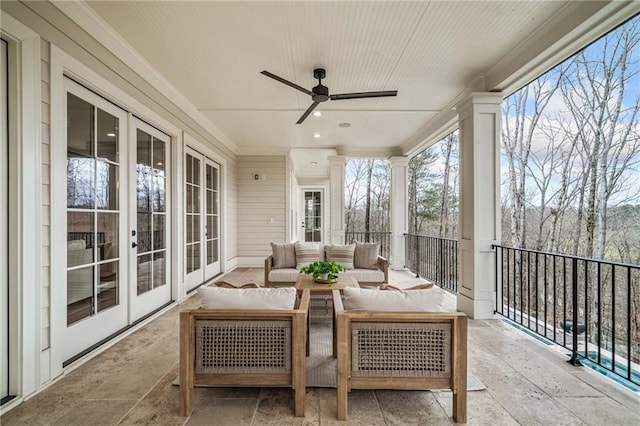 sunroom with stone tile floors, french doors, and ornamental molding
