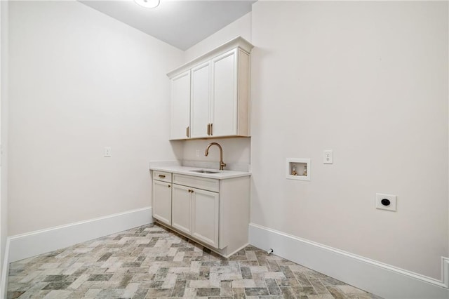 laundry area featuring a sink, hookup for an electric dryer, baseboards, cabinet space, and washer hookup