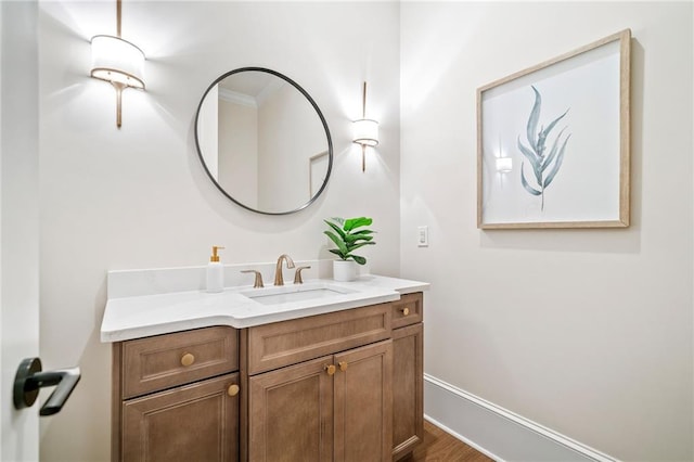 bathroom with baseboards, vanity, and wood finished floors