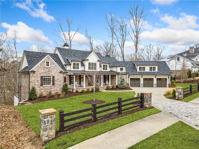 view of front of house with a front lawn, driveway, fence private yard, a porch, and a standing seam roof